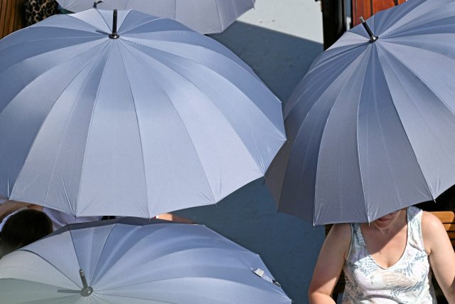 Wo die Bäume fehlen, müssen die Regenschirme herausgeholt werden, um sich vor der Sonne zu schützen.