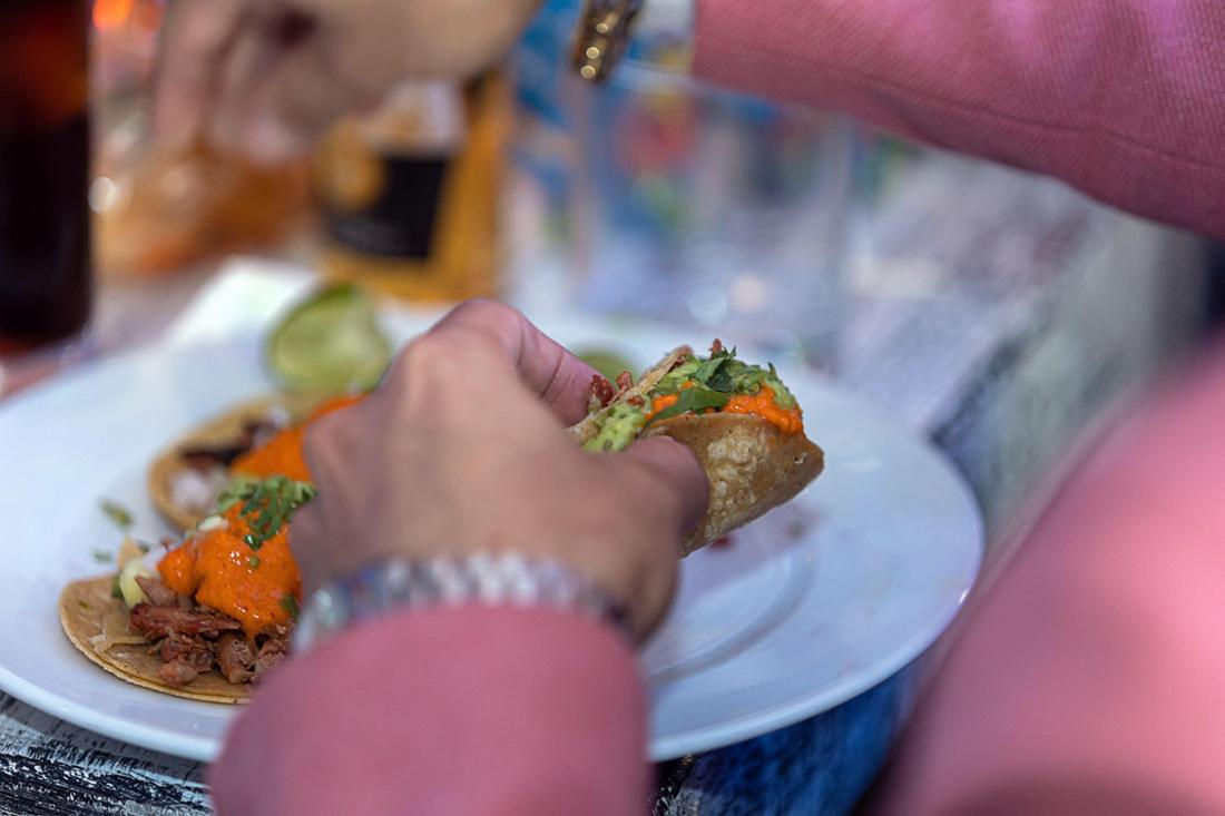 Eine Frau mit Tacos in der Hand.