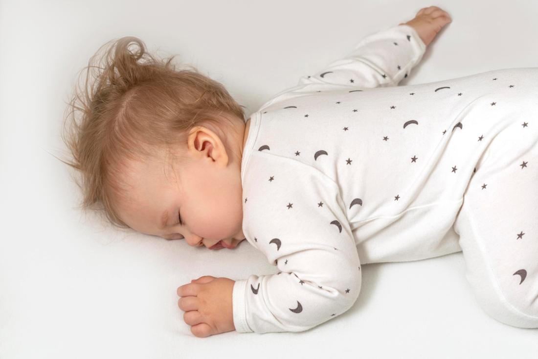 Baby schläft in weißem Pyjama schlaf bett krippe