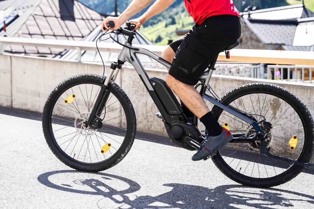 Mann fährt auf E-Bike in der Stadt.