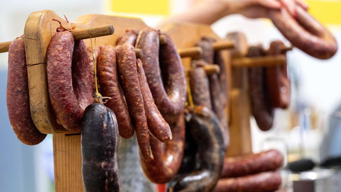 Verschieden Wurstsorten hängen an einem Holzstab