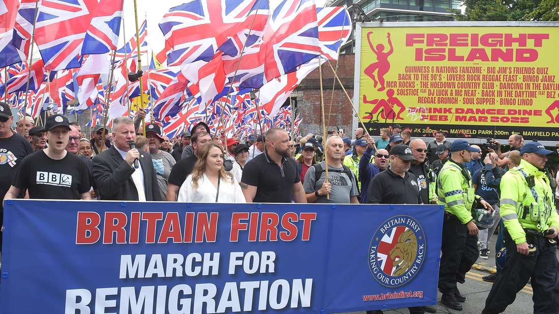 Far-right Britain First party co-leaders Paul Golding (front row 2L) and Ashlea Simon (front row C) lead supporters on an anti-immigration 'March for Remigration' calling for mass deportations, in Manchester, northwest England, on August 2, 2025.  (Photo by PETER POWELL / AFP)