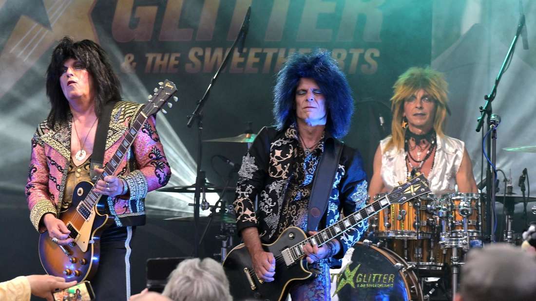 Open-Sound Göttingen: Prallvoller Wochenmarktplatz beim Konzert von Sweety Glitter mit Frontmann „Sweety“ Volker Petersen (links), Mitte: Gitarrist Randy B. Bluebird alias Eiko Witt sowie Drummer Sir Tobi, alias Tobi Zweifler. 