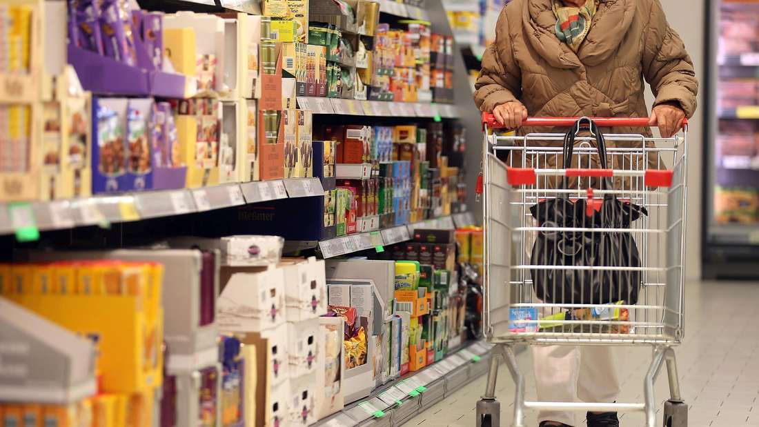 Eine Kundin schiebt ihren Einkaufswagen durch einen Discounter.
