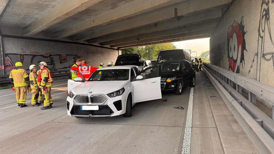 Autos stehen unter einer Autobahnbrücke, Einstzkräfte drumherum.