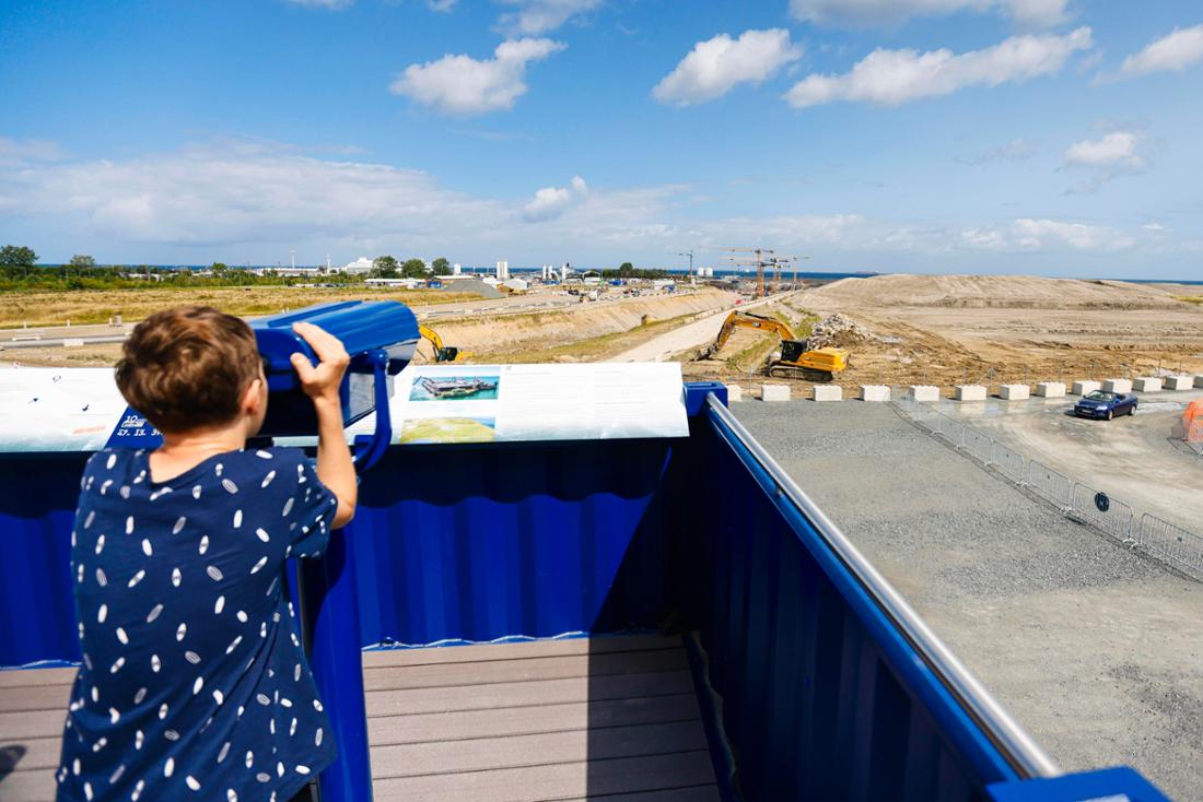 Ein Besucher schaut durch ein Fernglas auf der Aussichtsplattform der Baustelle des Fehmarnbelt-Tunnels. Das 55,1 Milliarden Kronen (rund 7,4 Milliarden Euro) teure Bauwerk soll die dänische Insel Lolland mit der deutschen Insel Fehmarn verbinden und aus 89 Betonelementen bestehen.