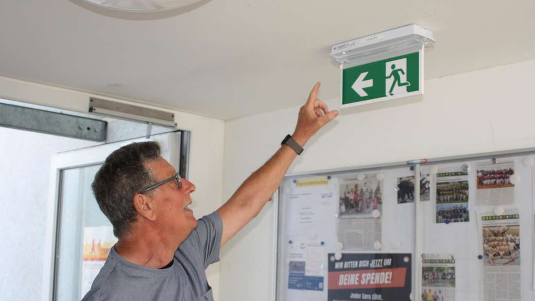 bab15082025 tv-halle babenhausen energie sparen Kurt Thiel mit einer der neuen Notausgangsleuchten Foto: Grimm