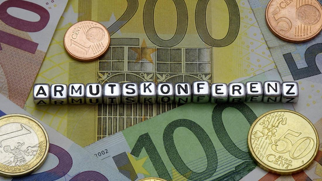 Geldscheine und Münzen mit Schriftzug Armutskonferenz