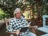 Eine Frau liest ein Buch in einem herbstlichen Garten (Symbolbild) - Neuerscheinungen im September