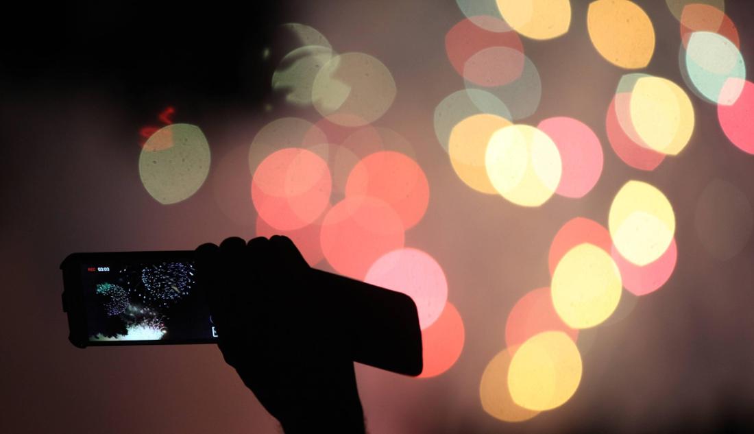 Eine Person fotografiert Feuerwerk