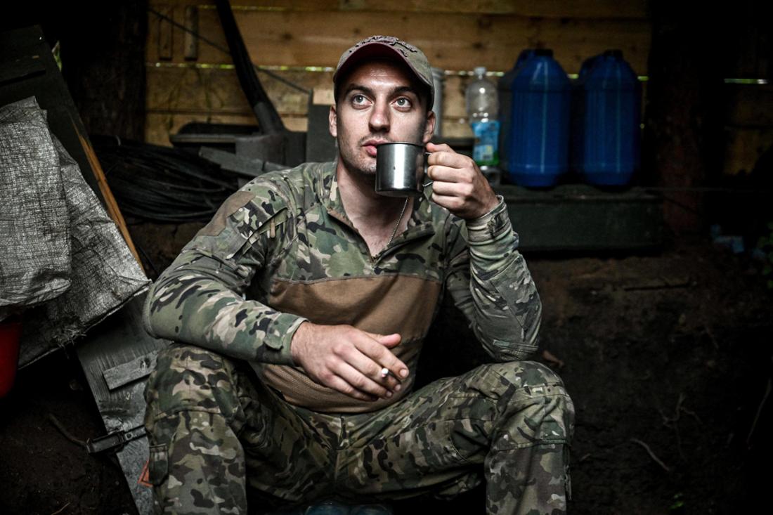 Ein Soldat raucht und trinkt Kaffee während einer Kampfpause in seinem Unterstand bei Pokrowsk