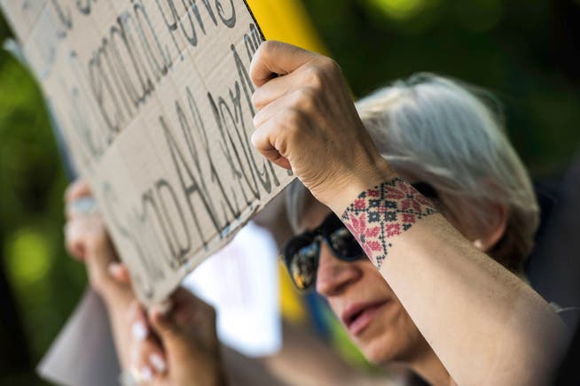 Vor der amerikanischen Botschaft in Kiew protestiert eine Ukrainerin gegen die Forderung nach einem Gebietsverzicht zugunsten Russlands.