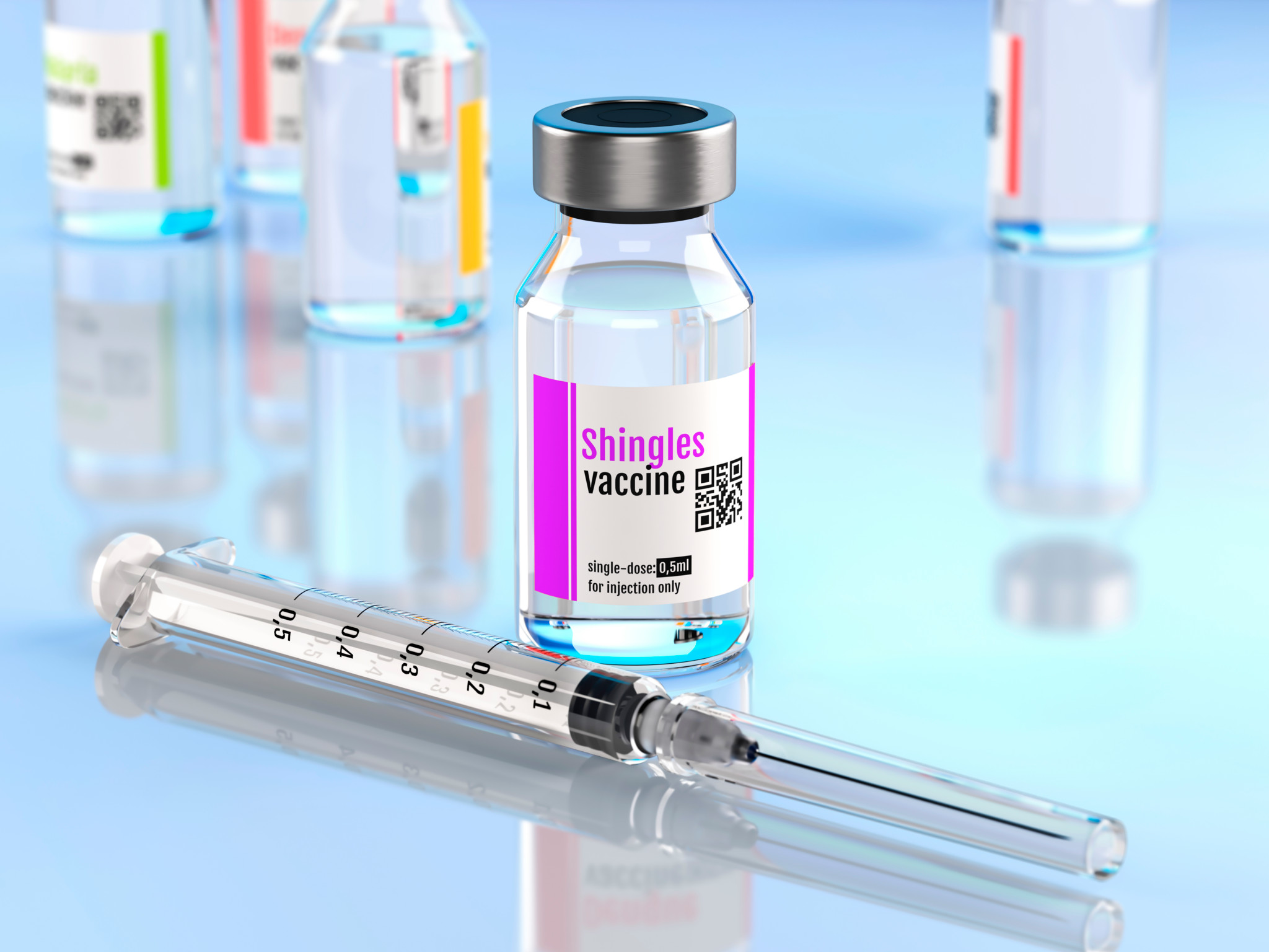 Illustration eines Impfstofffläschchens mit der Aufschrift ’Shingles vaccine’ und einer Spritze im Vordergrund, umgeben von weiteren Fläschchen.