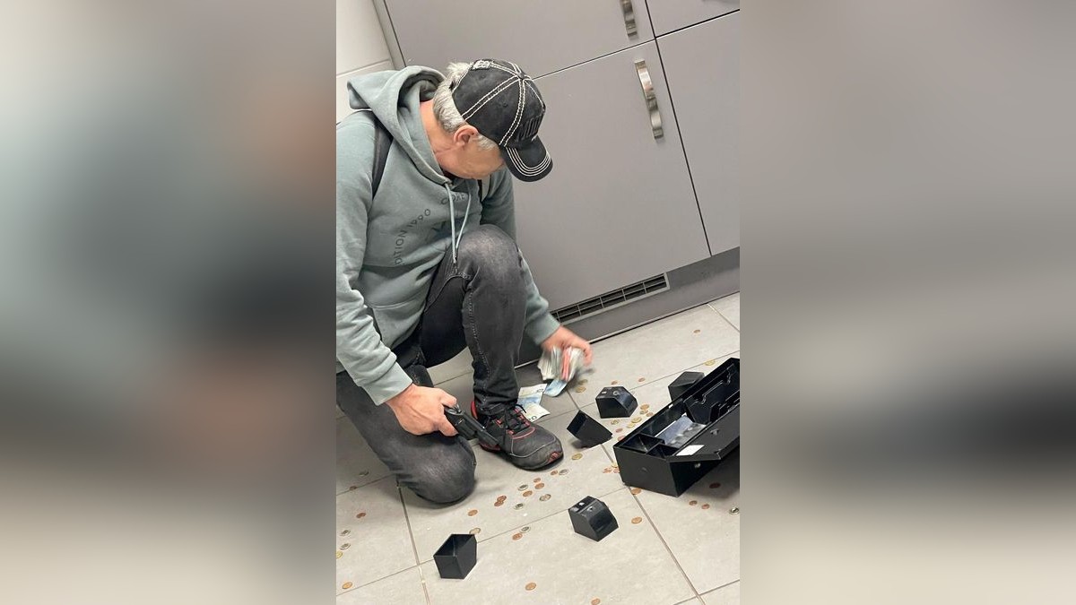 Der Täter sammelt hektisch Geld vom Boden ein. 