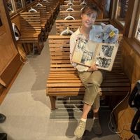 Gina Althoff sitzt im Schwebebahnwagen des Schwebodroms und zeigt das Fotoalbum in die Kamera.
