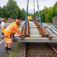 Die Vorbereitungen für die Sanierung der Bahnstrecke Berlin-Hamburg laufen: In Brieselang heben Arbeiter eine fertig montierte Weiche zum Transport vom Baumaterial-Lager zu einem nahe gelegenen anderen Lagerplatz. 