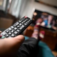 Mit der Fernbedienung vor dem Fernseher