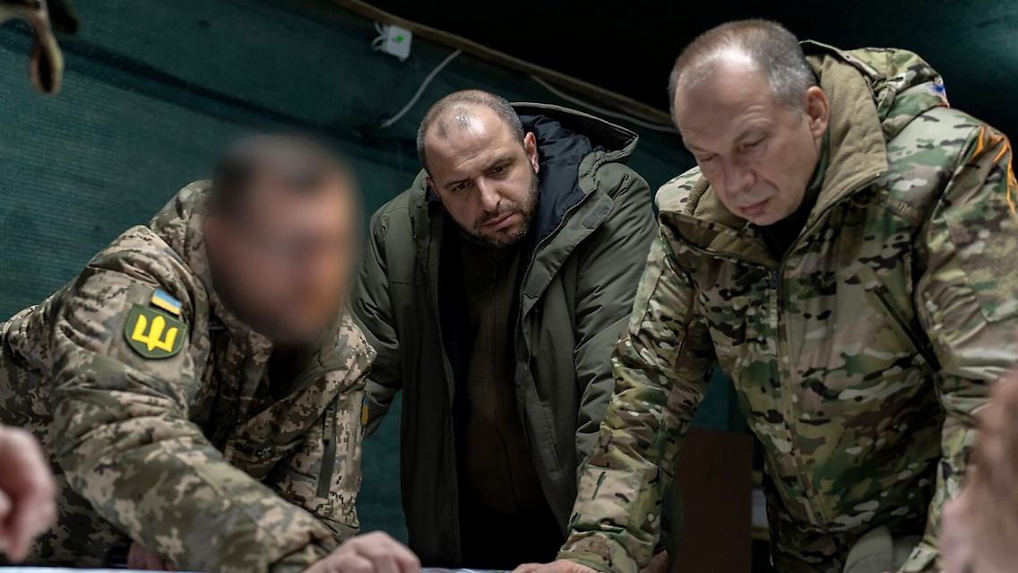 Rustem Umjerow (Mitte), ukrainischer Verteidigungsminister, und Olexander Syrskyj (rechts), Oberbefehlshaber der ukrainischen Armee, lassen sich in der Ostukraine die Frontlage erläutern.