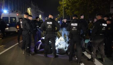 Polizisten umringen Sitzblockade.