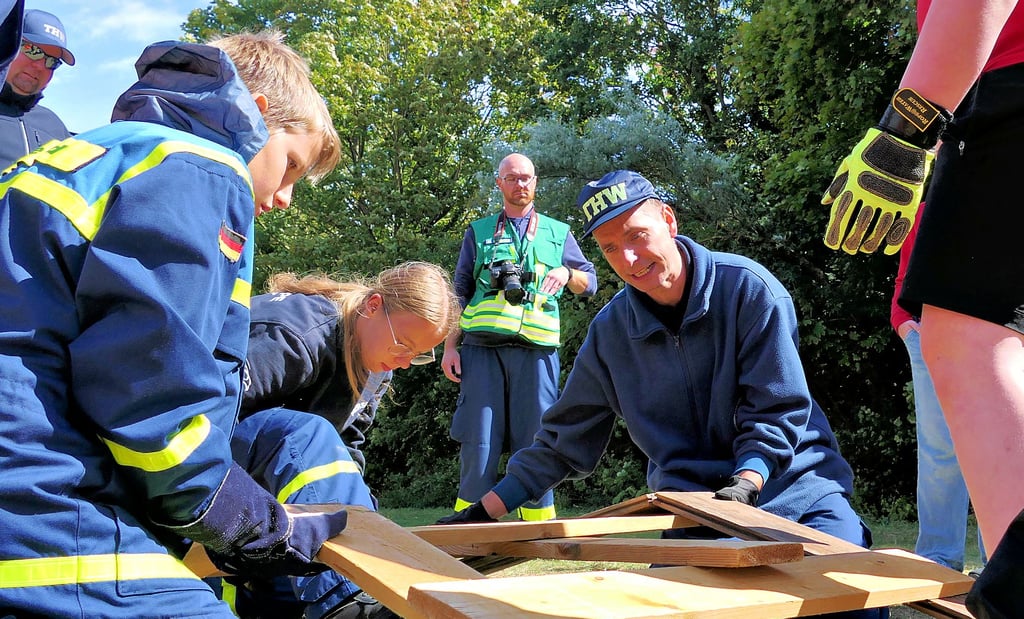THW-Helfer Andreas Kirchner erklärt dem Nachwuchs die Bauweise. Gebaut werden kann nur gemeinsam.