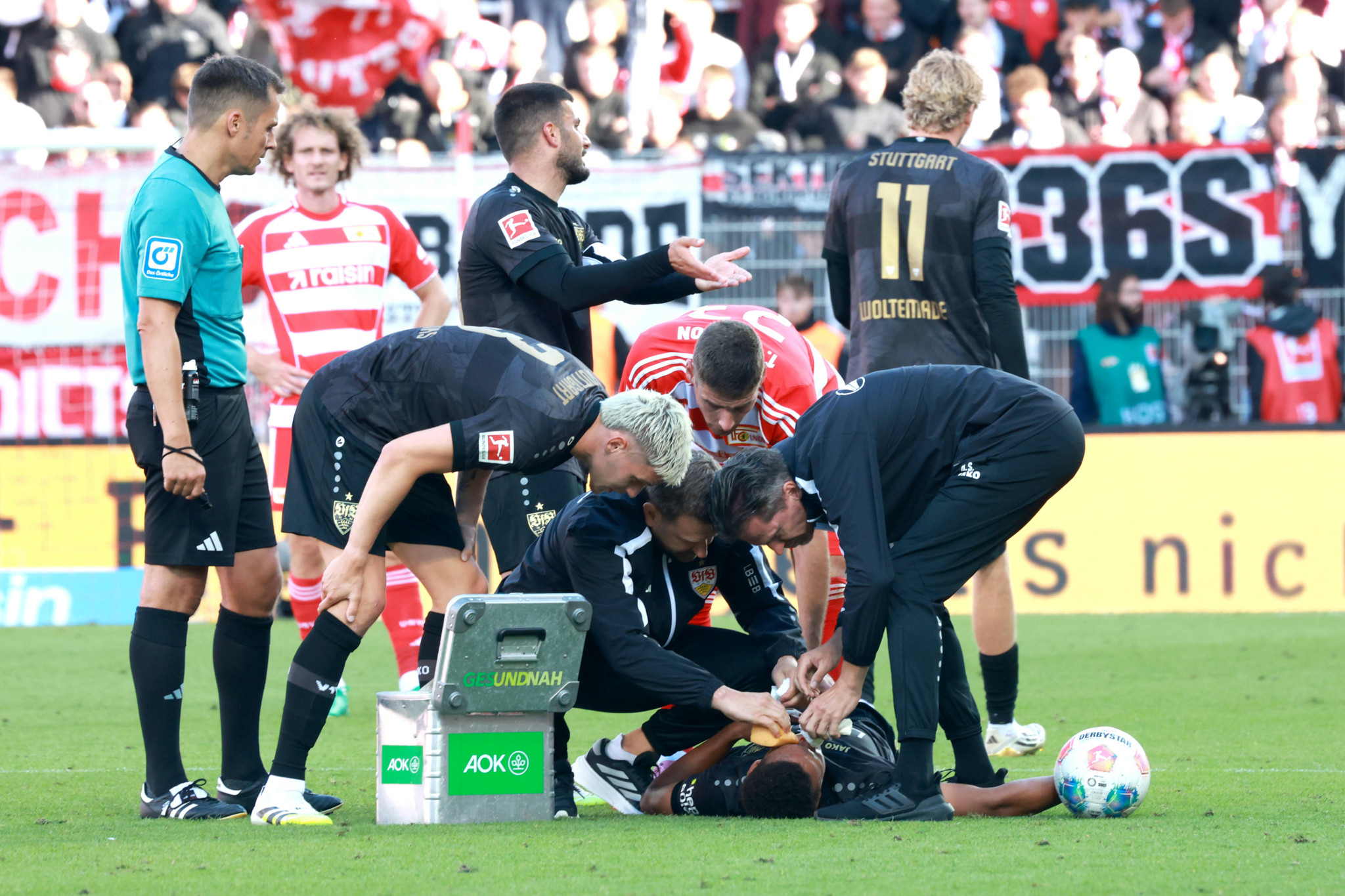 Mehrere Betreuer kümmern sich um den verletzten Luca Jaquez von VfB Stuttgart auf dem Spielfeld im Spiel gegen 1. FC Union, Stadion Alte Försterei, Berlin.