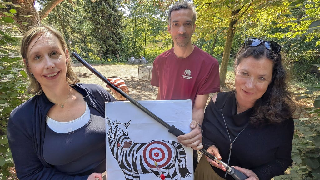 Zoochefin Dr. Simone Schehka (links), Sybill Ebers (Pferdemuseum) und Zoo-Tierarzt Dr. Carsten Ludwig freuen auf die Zoo-Nacht. Auf die Zebra-Zielscheibe kann mit dem Blasrohr gezielt werden.