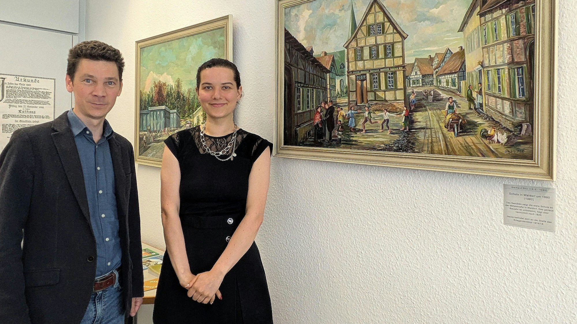 Dr. Simon Oelgemöller und seine Kollegin Nadine Glaeser vor einem Gemälde von Gerhard Ditz.