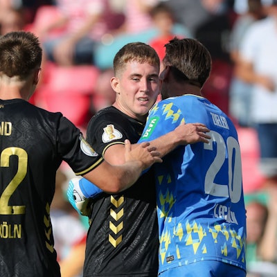 Isak Johannesson vom 1.FC Köln (M) wird Torwart und Kapitän Ron-Robert Zieler (r) und Kristoffer Lund vom 1. FC Köln nach dem Siegtreffer zum 2:1-Sieg bejubelt.