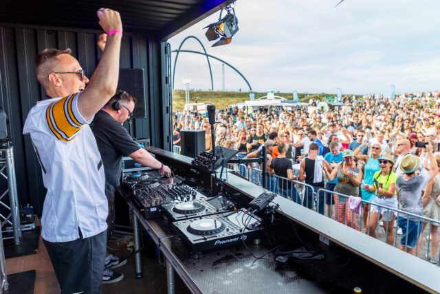 Zwei DJs stehen beim SunsetPicknick 2024 auf der Halde Hoheward in Herten auf der Bühne.
