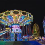 Ein Kettenkarussell steht auf der Annakirmes in Düren und strahlt bei Nacht in bunten Farben. 