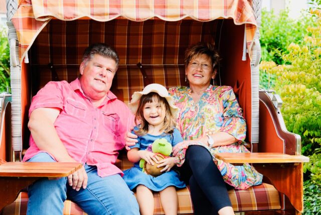 Ralf Marquardt, Leyana und Susanne Marquardt sitzen in einem Strandkorb im Garten der Familie.