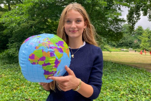 Die Hertenerin Elina Sturm hat einen Wasserball-Globus in der Hand und zeigt auf afrikanische Land Namibia.