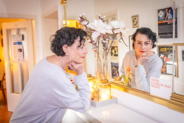Tirzah Haase guckt in den Spiegel in ihrem Wohnungsflur in Dortmund.
