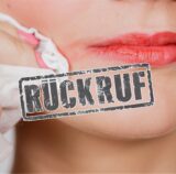 Eine Frau schminkt sich mit einem Reinigungstuch den Lippenstift ab.