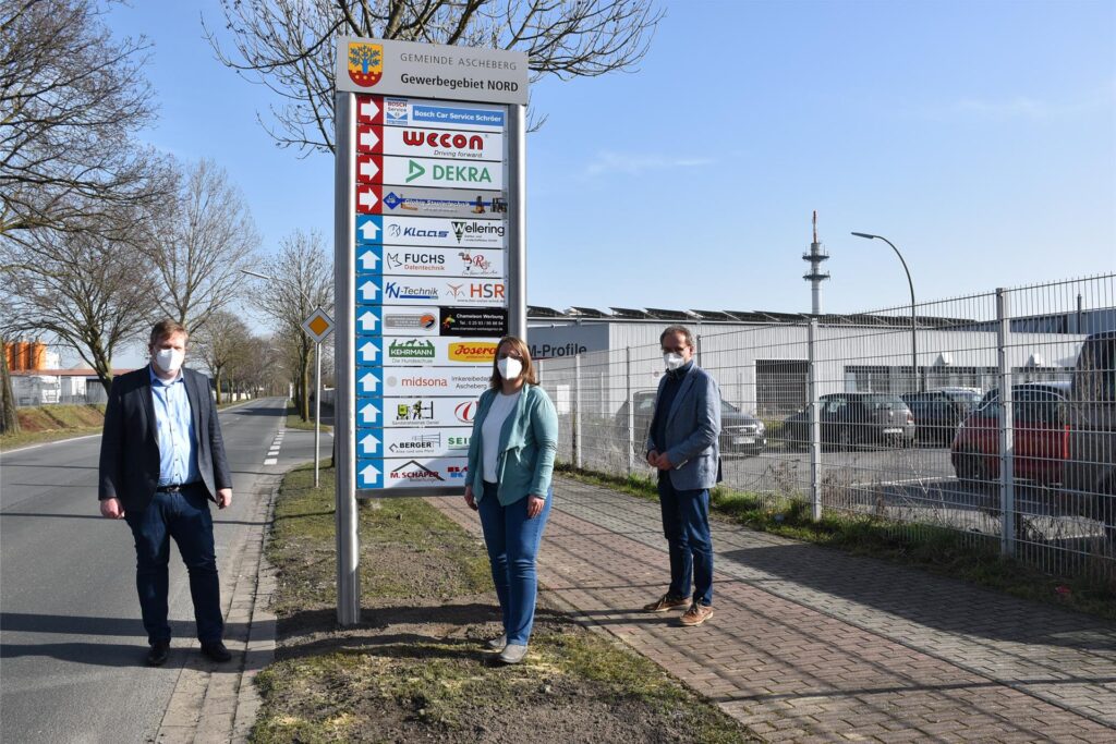 Bürgermeister Thomas Stohldreier und die Wirtschaftsförderer Simone Böhnisch und Helmut Sunderhaus (v.li.) stehen an den neuen Schildern im Gewerbegebiet Nord in Ascheberg.