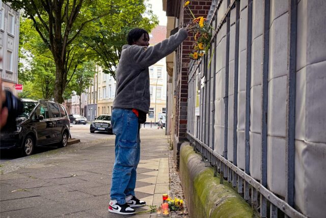 Lassana Dramé legt eine Blume für seinen getöteten Bruder Mouhamed ab.