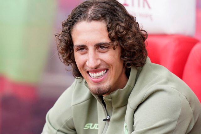 Fabio Silva sitzt auf einer Bank und lacht.