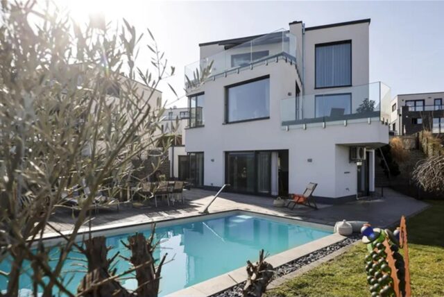 Blick auf das weiße Haus mit Pool davor