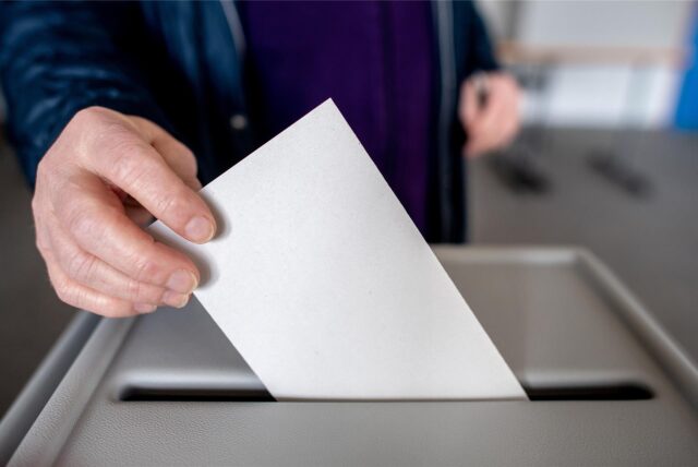 Ein Wähler wirft in einem Wahllokal seinen Stimmzettel für die Bundestagswahl in eine Wahlurne.
