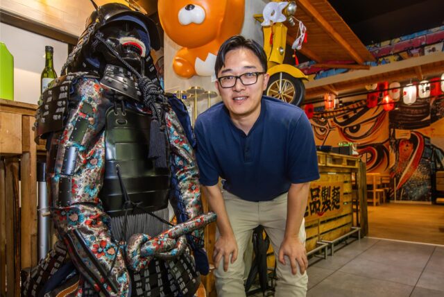 Yuan Gao steht neben einer Shogun-Statue in seinem Restaurant Ramen Ippin an der Kleppingstraße in Dortmund