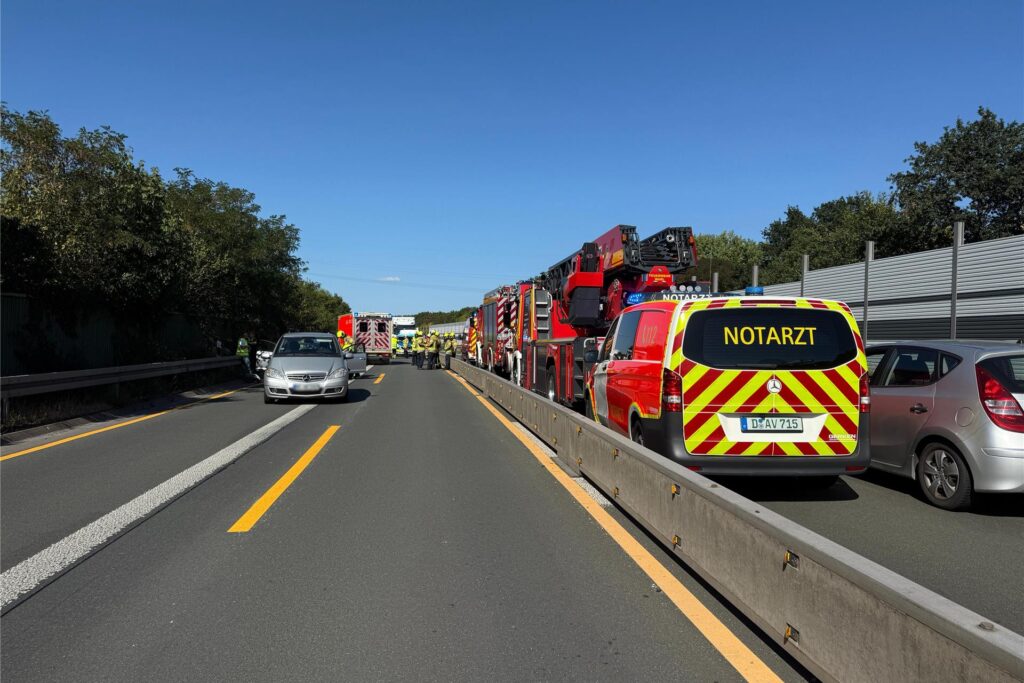 Auf einer Autobahn ist es zu einem Unfall gekommen. Einsatzkräfte von Feuerwehr und Notarzt sind vor Ort und sichern die Unfallstelle ab.