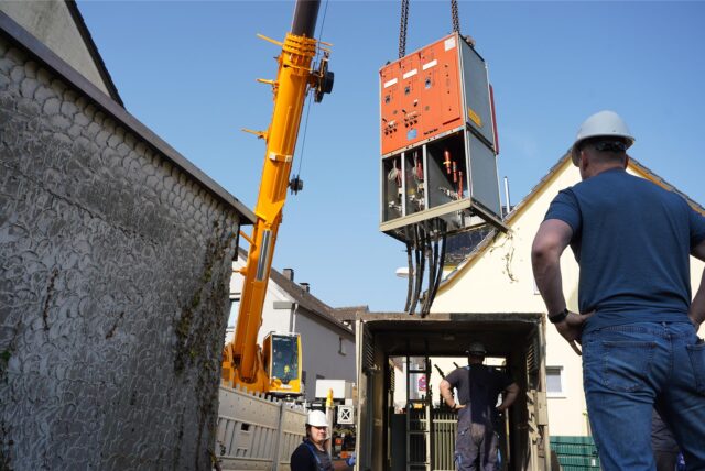 Ein Kran hebt die Technik der alten Trafostation in die Höhe.
