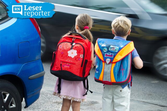 Zwei Schulkinder üben das Verhalten auf dem Schulweg und das richtige Überqueren einer Straße.
