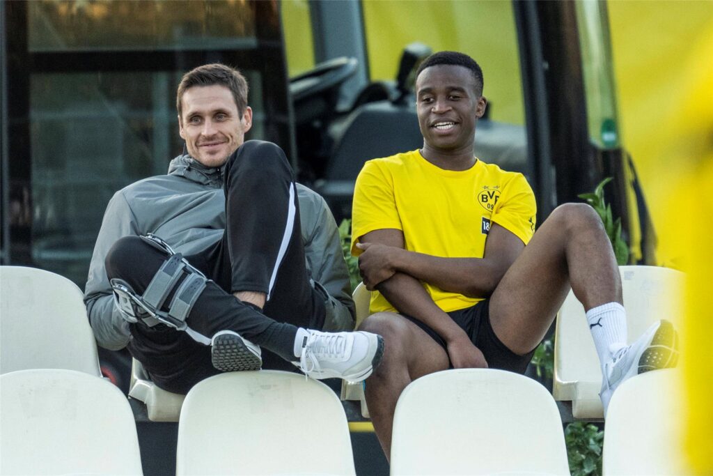 Sebastian Kehl sitzt neben Youssoufa Moukoko.