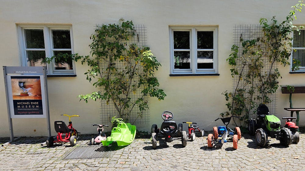 Neben dem Eingang zum Michael-Ende-Museum im Schloss Blutenburg steht für die jungen Gäste ein beachtlicher Fuhrpark zur Verfügung.