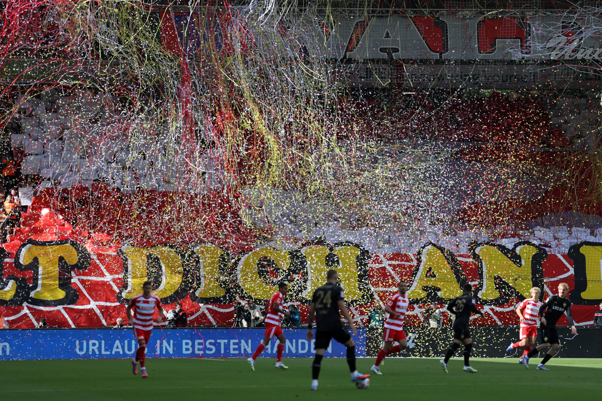 Fans von 1. FC Union Berlin zeigen ein Tifo mit rotem und weissem Text und farbigem Konfetti während eines Bundesliga-Spiels gegen VfB Stuttgart im Stadion An der Alten Försterei.