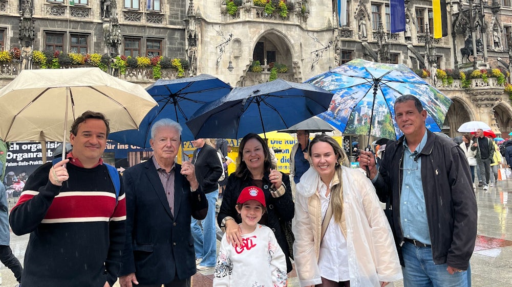 Sie lachen im Regen, auch wenn Ana Lidia Melolini (Mitte) und ihre brasilianische Familie „enttäuscht“ vom Münchner Wetter sind.