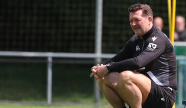 Cheftrainer Christian Titz beim Training auf einem Ball sitzend.