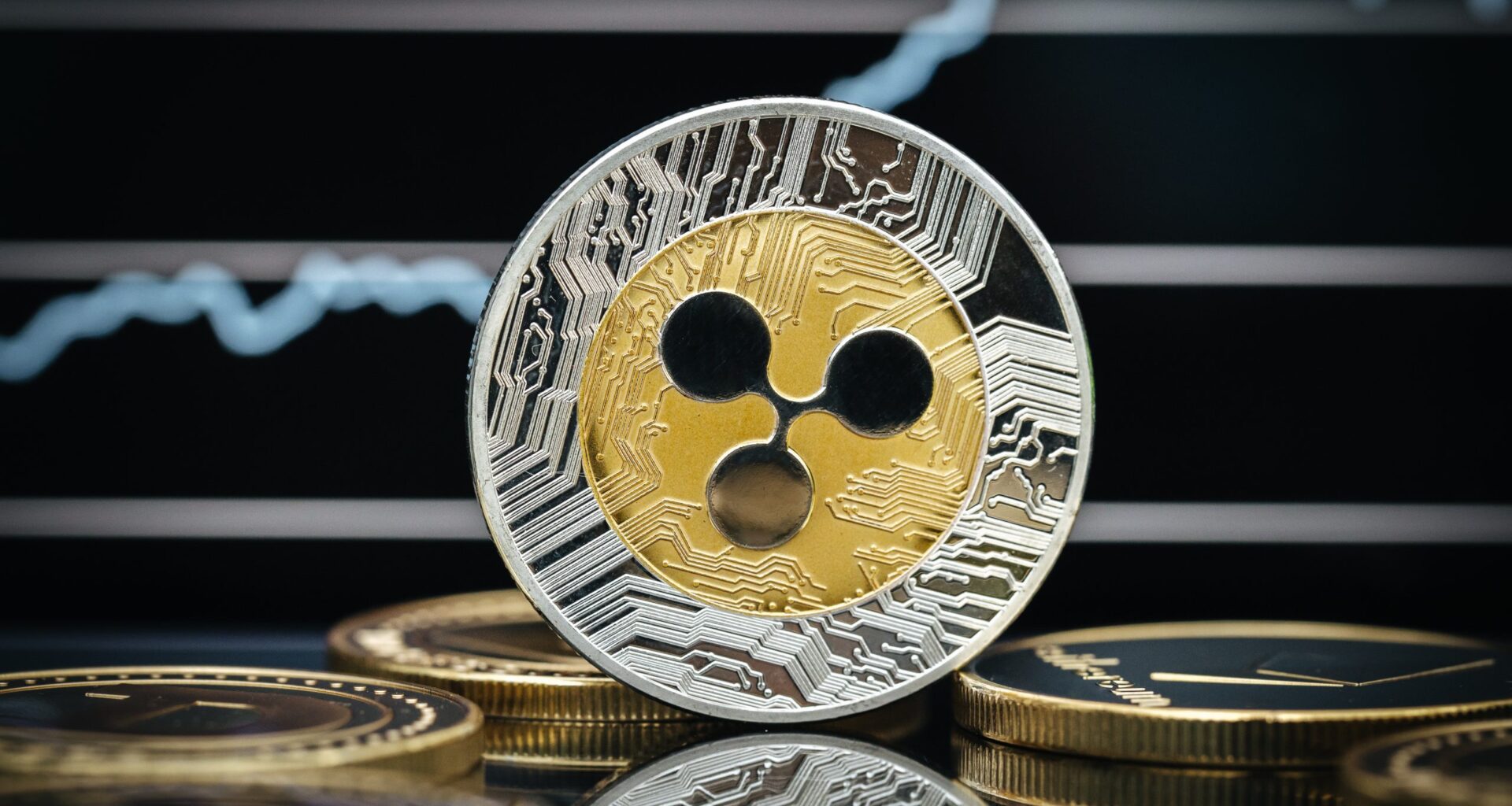 Eine Nahaufnahme eines Ripple-Coins (XRP), der aufrecht zwischen anderen Münzen steht, mit einem verschwommenen Graphen im Hintergrund, der auf eine XRP-Prognose und das Potenzial, 5 US-Dollar zu erreichen, hinweist.