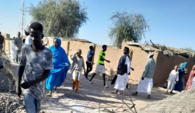 Mehrere Menschen gehen an einer Stelle in Al-Faschir vorbei, an dem ein Anschlag verübt wurde.